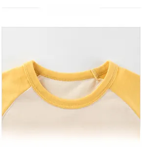 Détail du t-shirt pour bébé avec manches raglan jaunes et col rond en maille côtelée