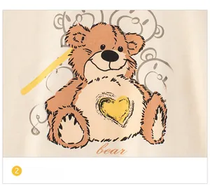 Détail de l'imprimé d'ours mignon avec cœur jaune sur t-shirt beige pour enfant