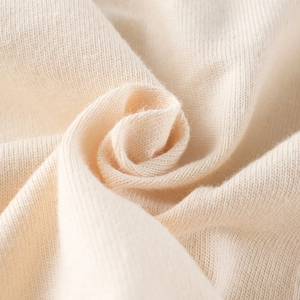 Close-up of soft cream knit fabric texture on long sleeve kids t-shirt with cozy feel