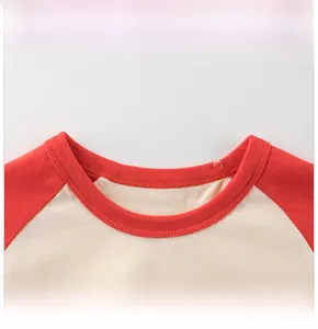 Detail eines gerippten Rundhalsausschnitts und verstärkter Nähte an einem rot-beigen T-Shirt