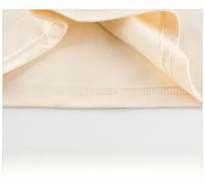 Détail de la double couture de l'ourlet sur le t-shirt en coton beige pour enfants
