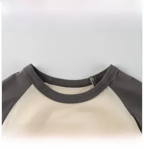Détail de l'encolure en coton avec manches raglan grises et coutures soignées