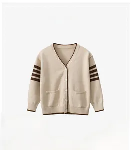 Detail of beige knit cardigan for kids with brown V-neck trim and striped sleeves