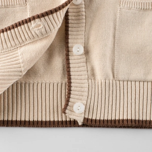 Cream knit cardigan with brown striped edges and white buttons for little girls
