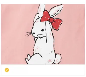 Gros plan d'un lapin blanc mignon avec nœud à pois rouges sur un t-shirt rose en coton