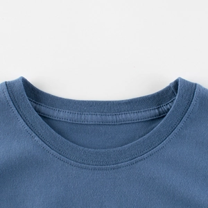T-shirt bleu en coton pour enfant montrant les détails du col et des coutures de qualité