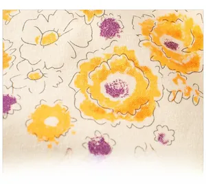Gros plan sur un tissu en coton doux avec des motifs floraux peints en jaune et violet