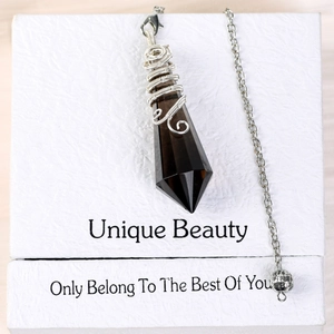 Brown crystal pendulum pendant with wire wrap on white textured gift box