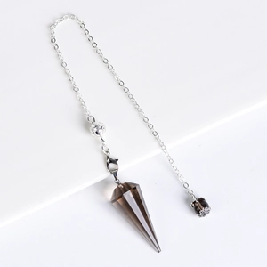Smoky quartz crystal pendulum with silver chain for divination on white pedestal