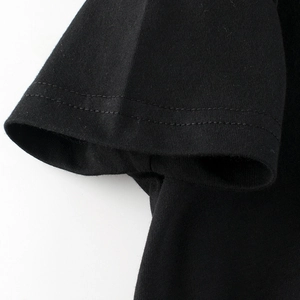 Dettaglio della cucitura a doppio ago resistente sulle maniche della T-shirt nera in cotone