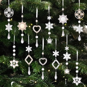 Close-up of snowflake and star acrylic pendants with faux pearls on a Christmas tree