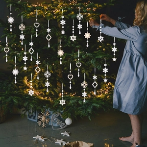Close-up of sparkling acrylic snowflake and star ornaments on a festive Christmas tree
