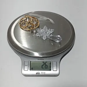 Close-up of clear acrylic snowflake ornament weighing 26.1g on a digital scale