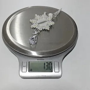 Macro shot of a snowflake crystal pendant on a digital scale showing a weight of 13.0g