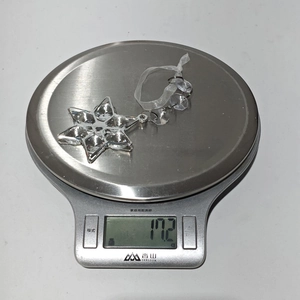 Detail shot of acrylic snowflake pendant weighing 17.2g on a digital scale