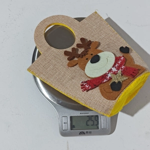 Detail of reindeer Christmas gift bag weighing approximately 25.9g on a digital scale