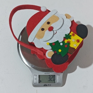 Detail shot showing a 32.0g Santa Claus felt gift bag weighed on a digital kitchen scale
