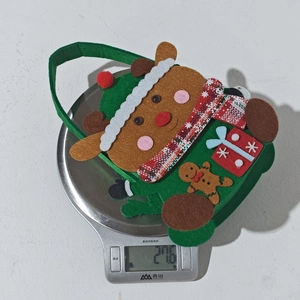 Detail view of cartoon reindeer Christmas gift bag weighing 27.6g on a kitchen scale