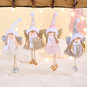 Close-up of four plush pink and grey angel doll ornaments hanging on a wooden branch