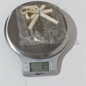 Detail shot of a golden snowflake ornament with ribbon and crystal on a kitchen scale