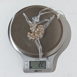 Close-up of lightweight acrylic ballet dancer ornament with gold sequins on scales