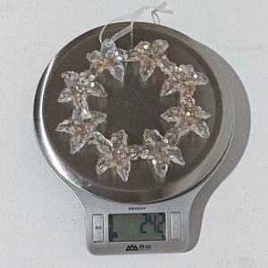 Detailed view of clear acrylic star ornament with gold sequins weighing 24.2g