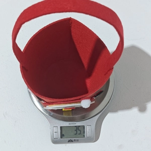 Detailansicht einer roten Filz-Weihnachtstüte auf einer Waage mit Gewicht 35,1g