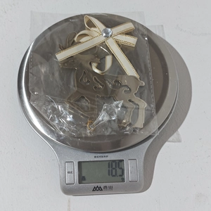Detailed view of champagne gold metal elk ornament with crystals and bow on a kitchen scale