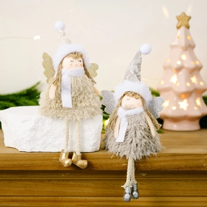 Detail showing plush Christmas angel doll ornaments with sparkly wings on a wooden surface
