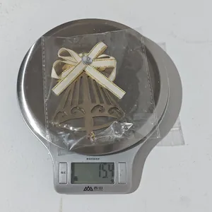 Detail of hollow metal bell pendant with bow and faux crystal weight on kitchen scale