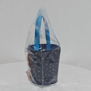Detail of blue denim Christmas gift bag with gold star pattern in plastic packaging