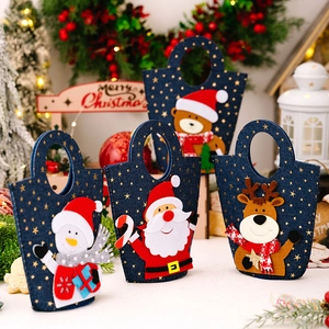 Detailed view of four denim Christmas gift bags featuring Santa and snowman embroidery