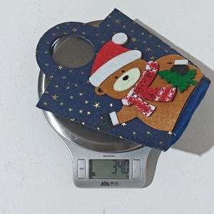 Detailed view of lightweight Christmas bear gift bag with gold stars on electronic scale