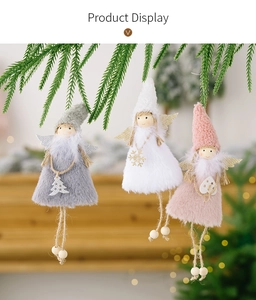Pink and white plush Christmas angel ornaments hanging on a festive tree branch