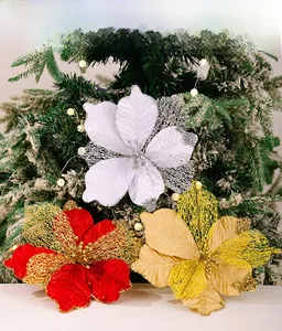 Detail of red and gold artificial Christmas poinsettia flowers with glitter on Xmas tree