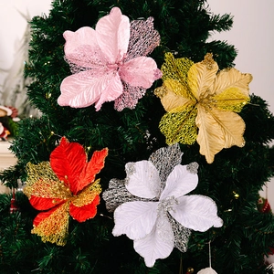 Detail of glittered artificial poinsettia flowers in pink, gold, and red on Christmas tree