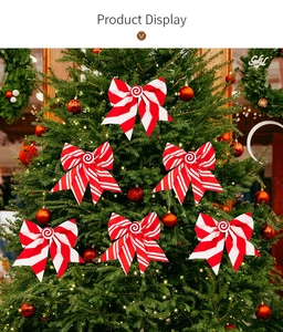Detail of red and white striped Christmas bows with lollipop center on a glowing tree