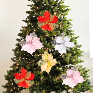 Sparkling artificial poinsettia flowers with gold glitter on a decorated Christmas tree