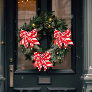 Three red and white candy cane striped Christmas bows decorated on a green pine wreath