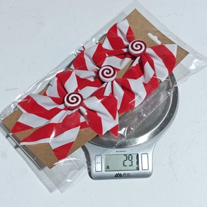 Weight display of red and white striped Christmas bow ornaments on a digital scale