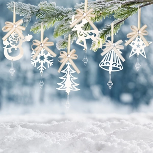 Witte kerstversiering met strikken en ijspegels hangend aan besneeuwde dennentakken in bos