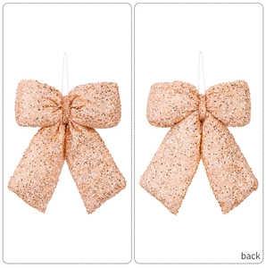 Macro detail of 3D gold sequin bow hanging decoration for Christmas trees and weddings