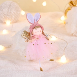 Detail of plush Christmas angel with pink bunny ears and gold wings on star mesh skirt