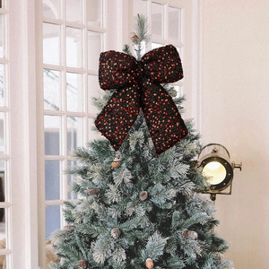 Close-up of a large festive Christmas tree topper bow with sparkling red and orange sequins