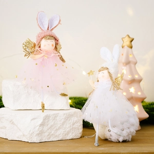 Pink and white Christmas angel ornaments with rabbit ears and golden wings on a pedestal
