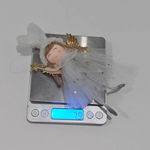 Detailed scale view of a plush Christmas angel ornament with bunny ears and gold wings