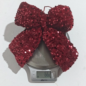 Detailed view of a sparkling red sequin Christmas bow pendant weighing 66.2 grams