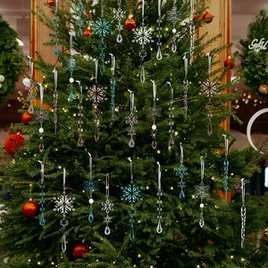 Transparent acrylic snowflake and icicle ornaments hanging on a green Christmas tree