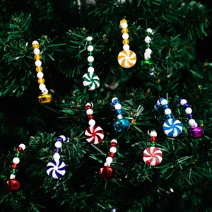Detail van rood-witte zuurstokken met kleurrijke kralen en bellen op een kerstboom
