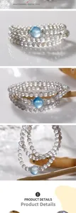 Detailed close-up of 6mm grey moonstone triple-wrap bracelet with aquamarine accent bead